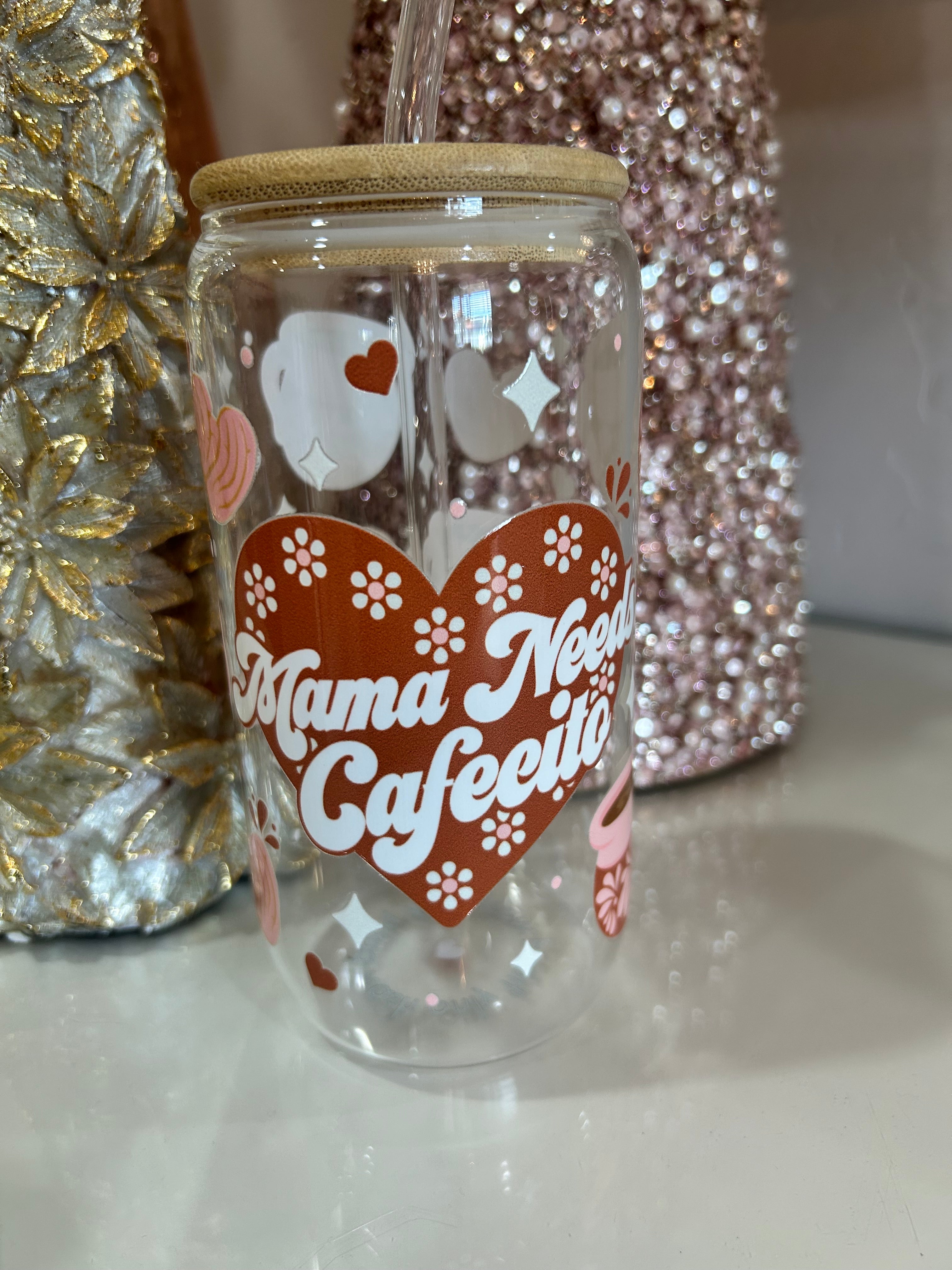 Clear glass tumbler cup with "mama needs cafecito" text and design.