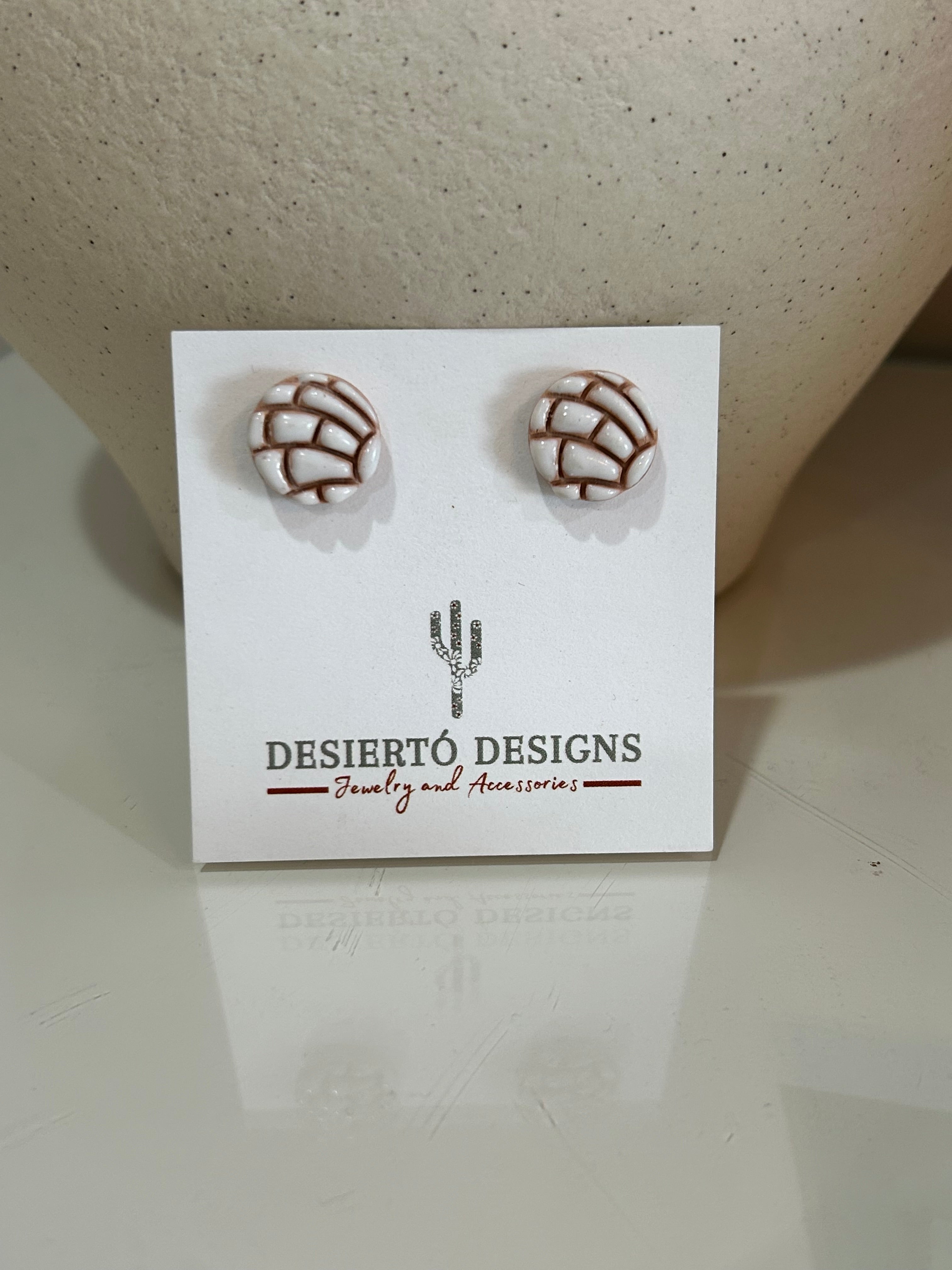 White concha stud earrings pair on a backing card.