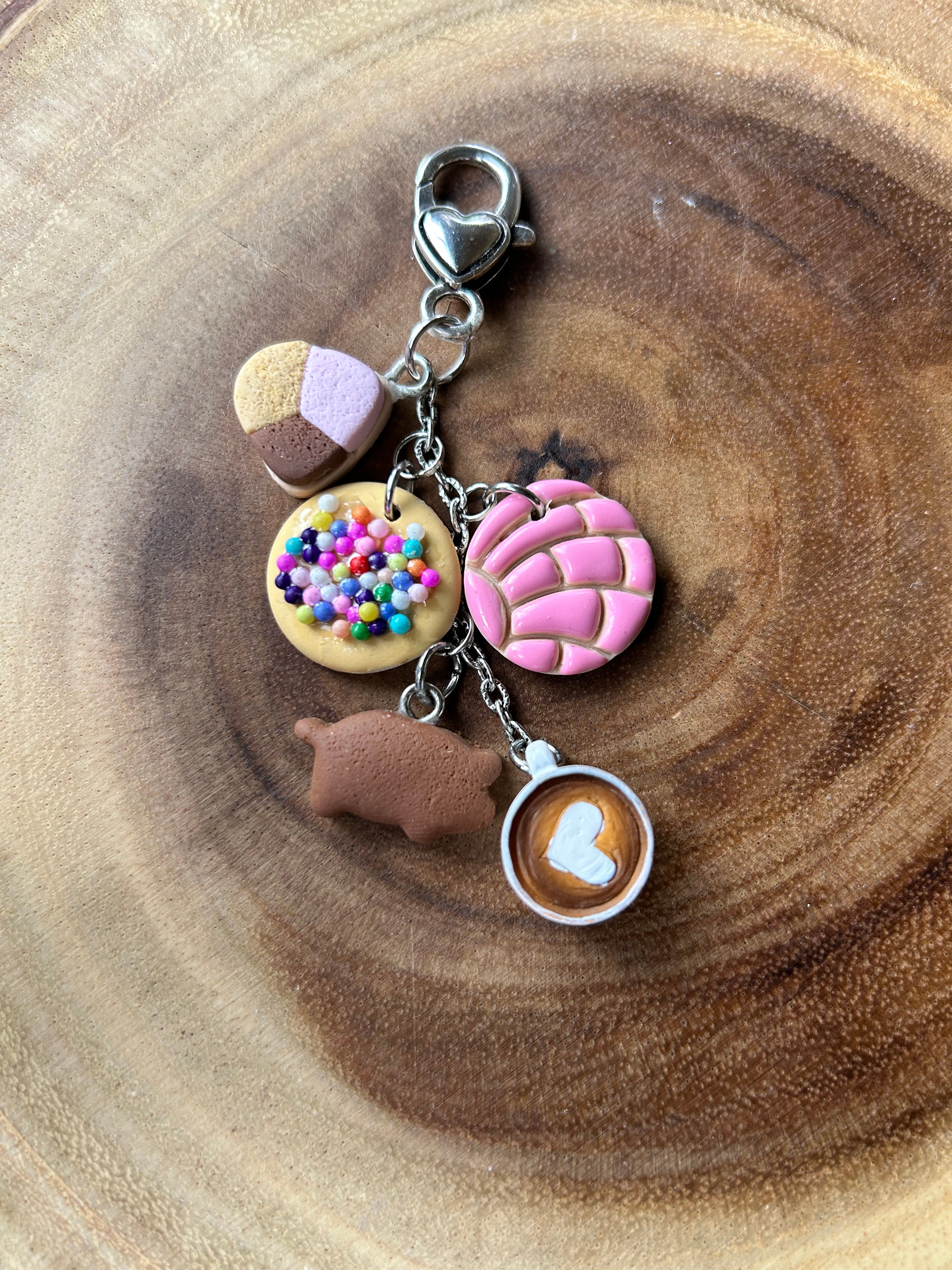 Pan dulce keychain with five handmade charms against a wooden background.